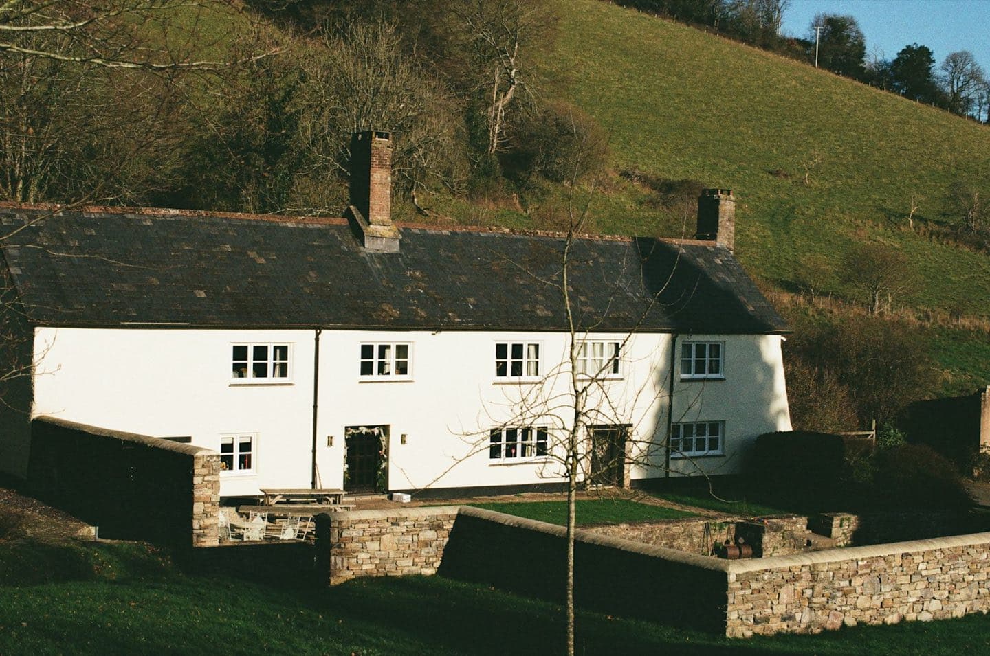 The white stone farmhouse of Hollow Ash set against a green Dales hillside